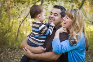 Happy couple with toddler in a woodland park